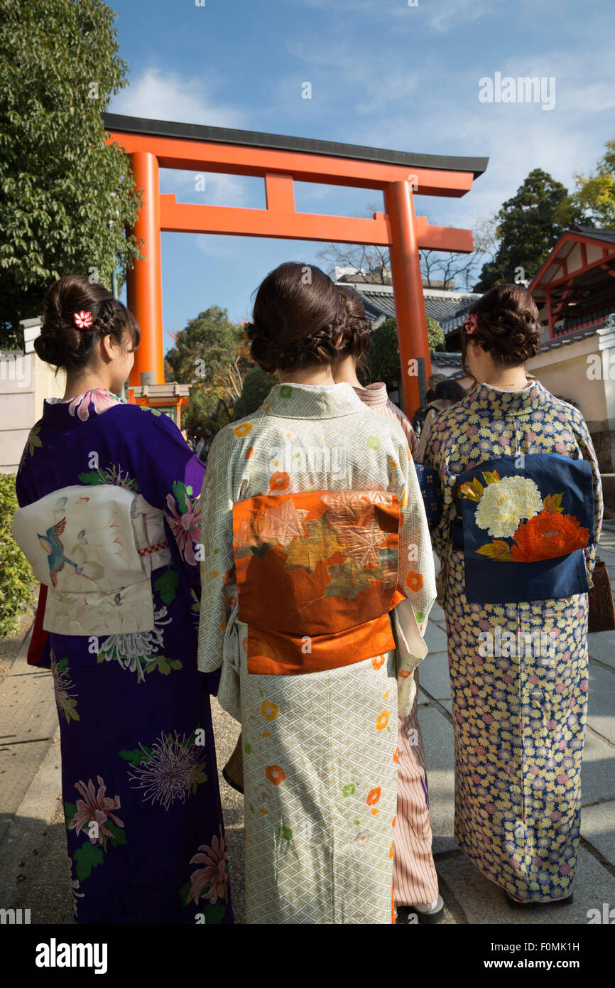 Young Japanese girls below torii gate in traditional kimonos, Yasaka Shrine, Kyoto, Japan, Asia Stock Photo