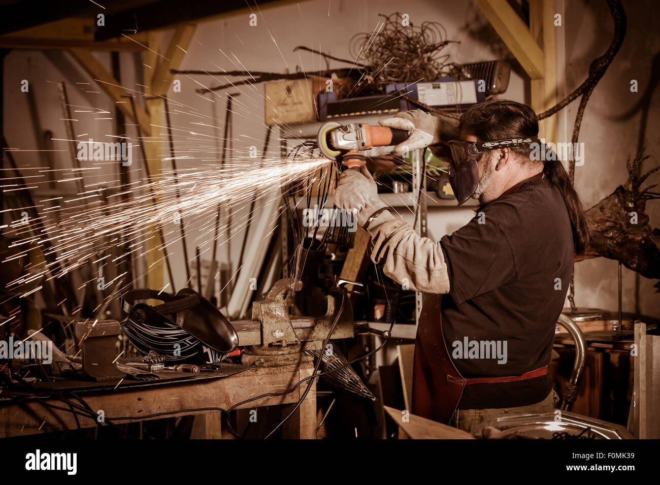 Metal worker Grinding with sparks in workshop Stock Photo