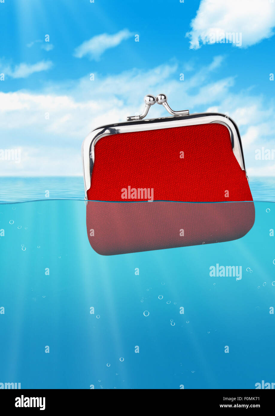 sinking red wallet at ocean, colorful finance concept Stock Photo