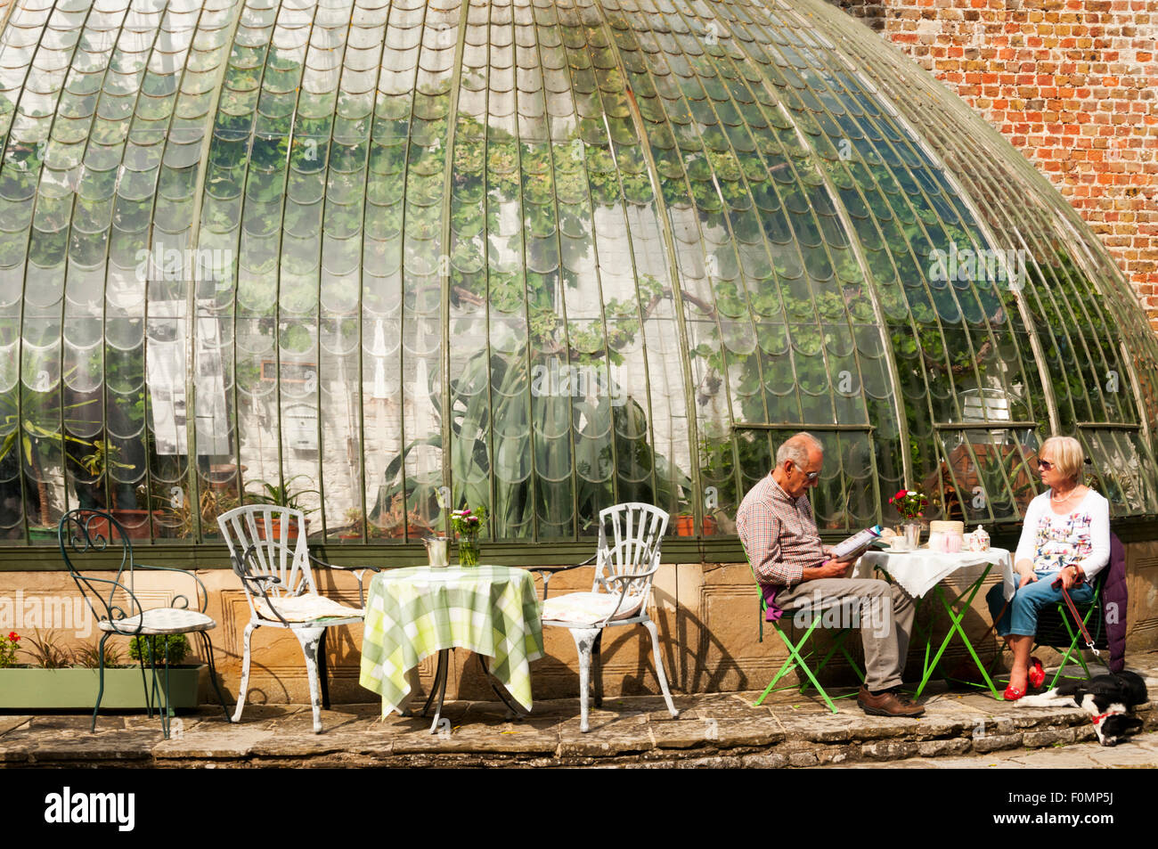 A couple relaxing over a pot of tea at the tea garden next to the Italianate greenhouse in George VI Park, Ramsgate. Stock Photo