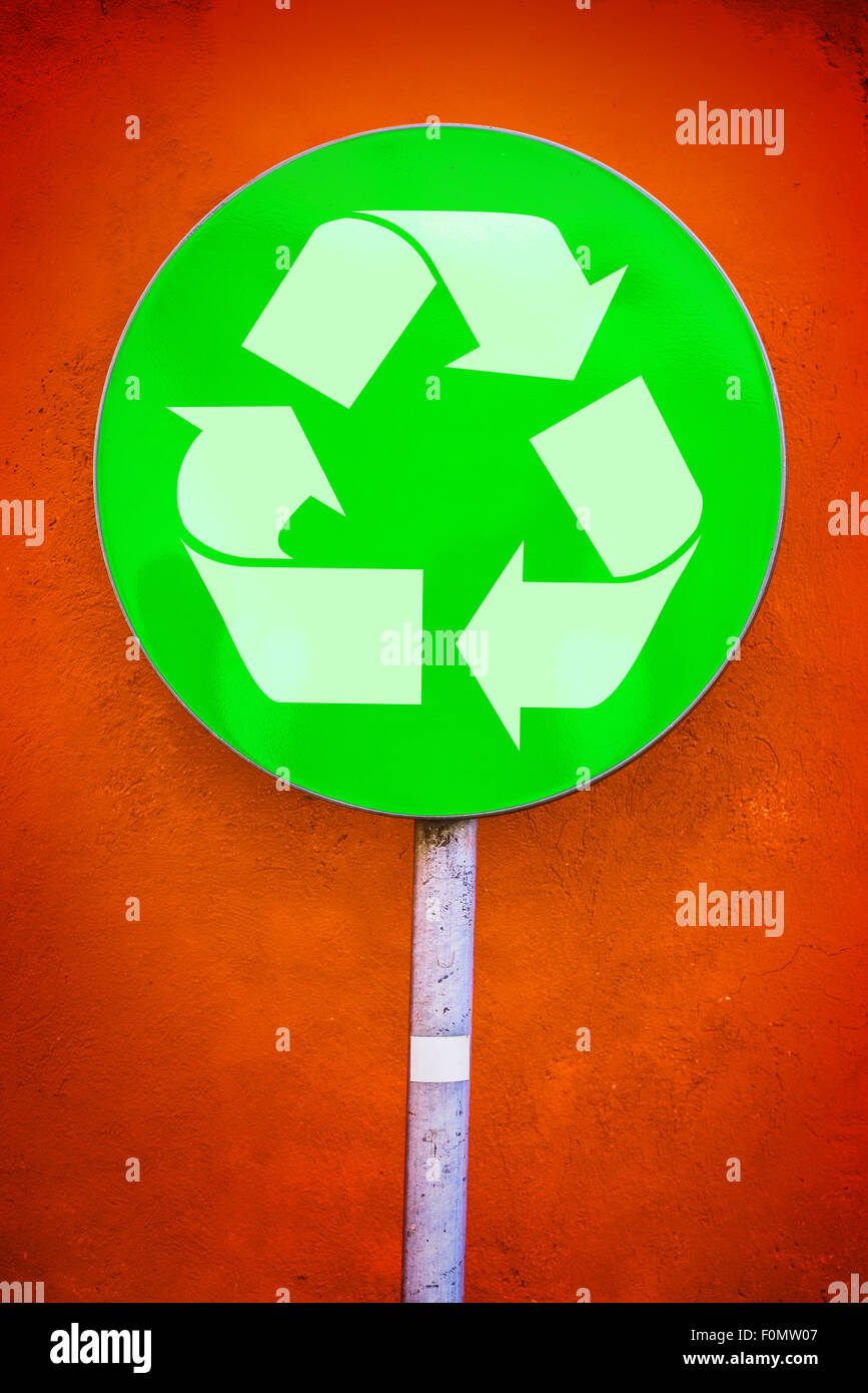 Recycle Symbol on Green Ecology Round Traffic Sign Against Orange Grunge Wall, Urban Environmentalist Concept Stock Photo