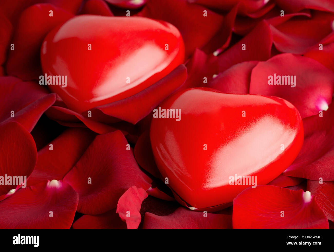Love background. Red hearts on rose petals Stock Photo - Alamy