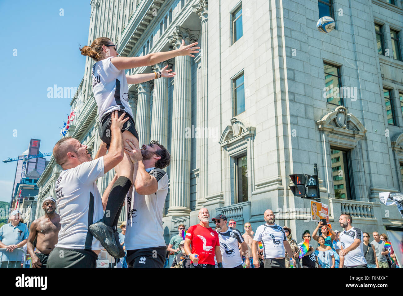 MONTREAL, CANADA, 16th August 2015. A female member of the gay rugby team is catching the ball at the 2015 Gay Pride Parade in Montreal. © Marc Bruxelle/Alamy Live News Stock Photo
