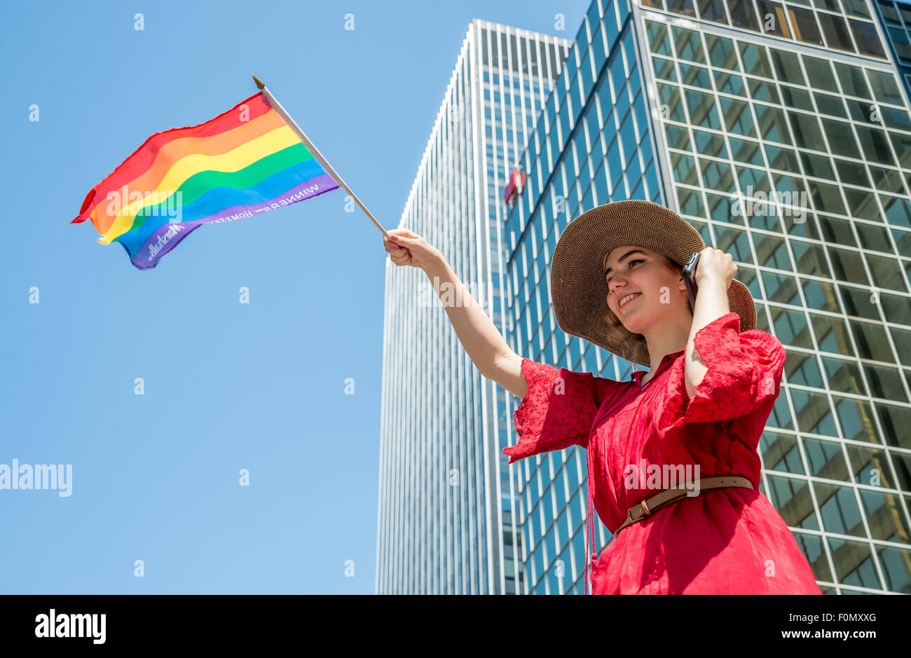 MONTREAL, CANADA, 16th August 2015. A female spectator is waving the gay rainbow flag at the 2015 Gay Pride Parade in Montreal. © Marc Bruxelle/Alamy Live News Stock Photo