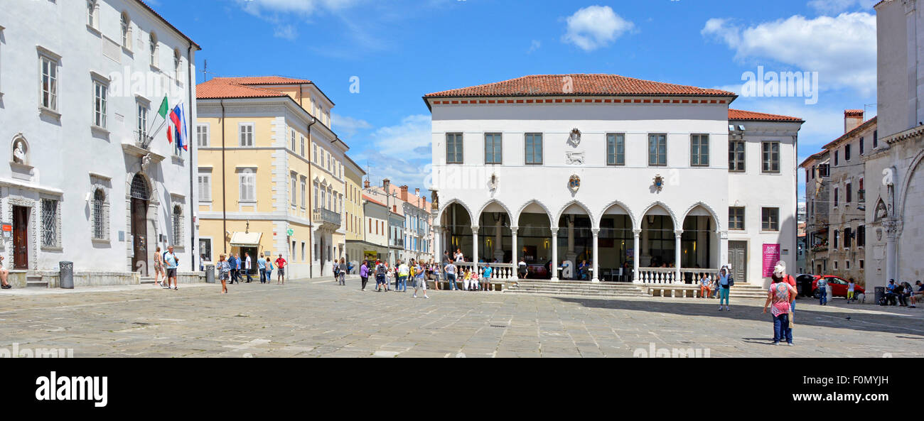 Tourists & locals in Tito Square Koper with arched Venetian Gothic Loggia Palace now home to café on ground floor Slovenia Istrian Peninsula Stock Photo