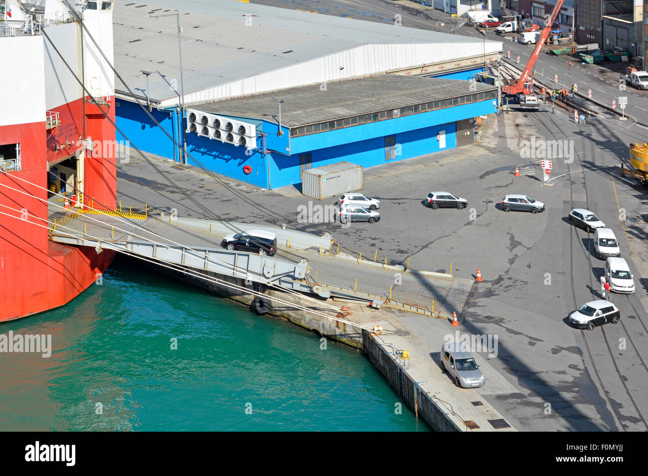 Aerial view looking down on Port of Koper new export cars being driven across dockside onto ramp to car carrier ship named Le Mans Express in Slovenia Stock Photo