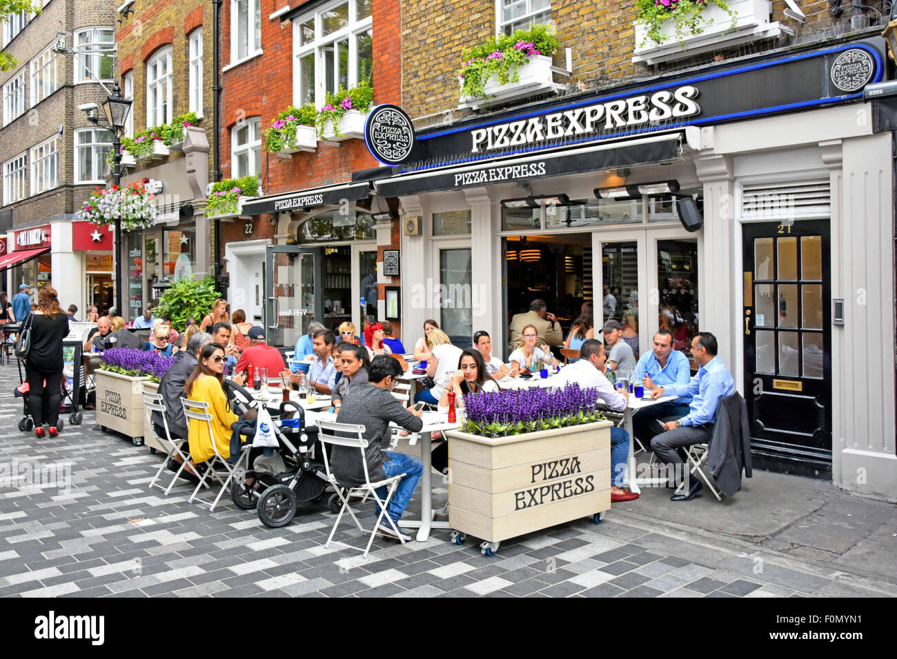 Pizza Express pizza restaurant with people eating out dining outdoors in St Christophers Place off Oxford Street alfresco dining London West End UK Stock Photo
