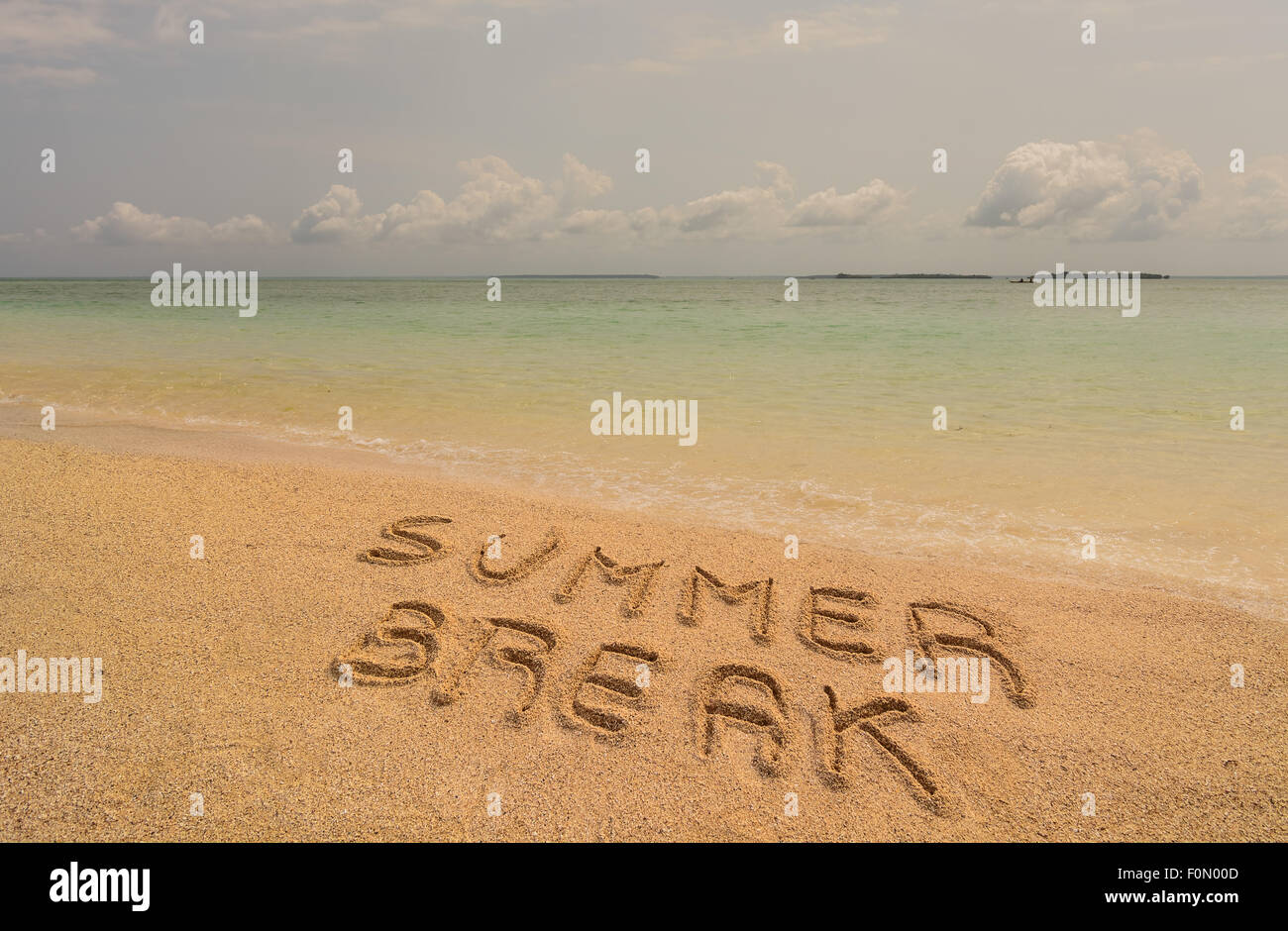 In the photo a beach in Zanzibar in the afternoon where there is an inscription on the sand 'Summer Break'. Stock Photo