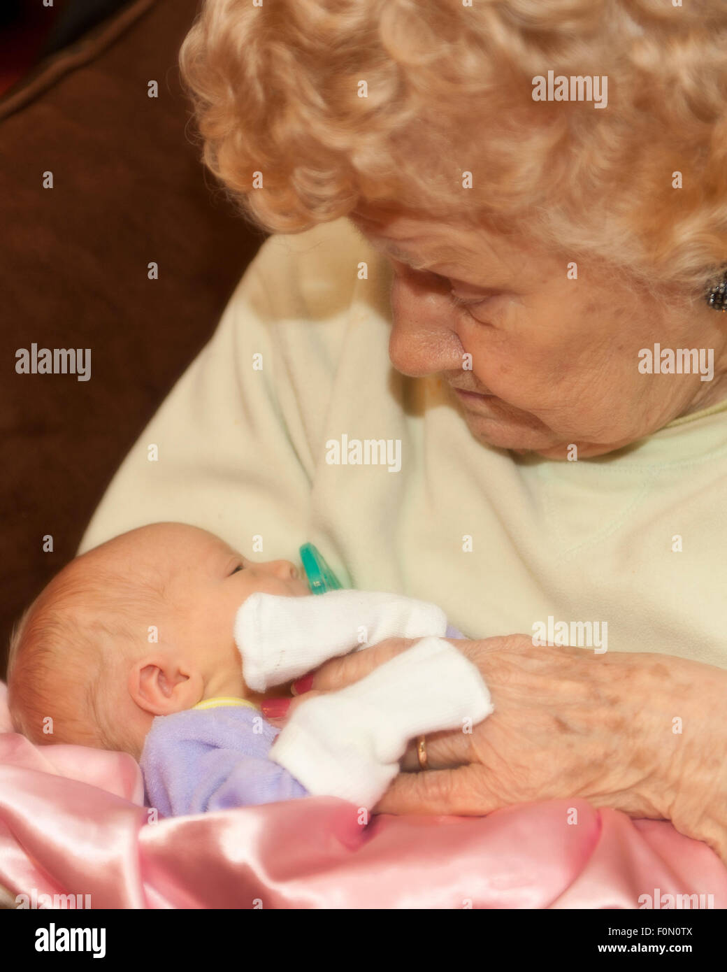 Great grandmother holding her infant great granddaughter Stock Photo