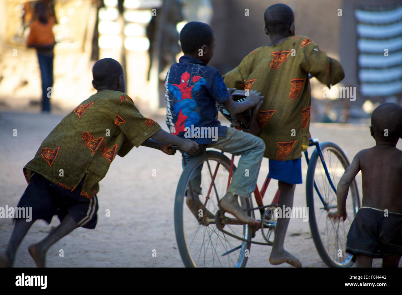 Kids playing on a bike in Africa. Stock Photo