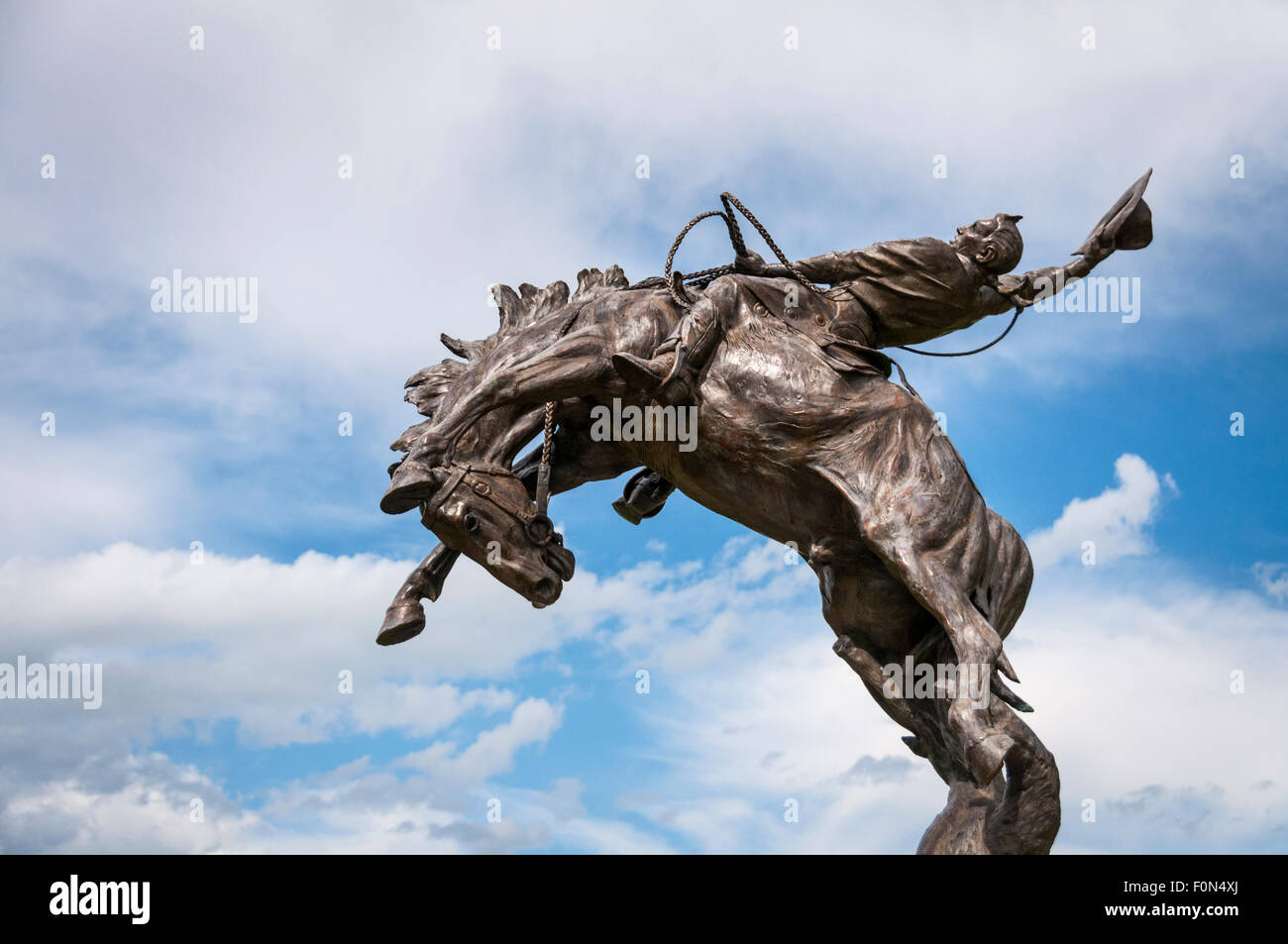 Bronze statue of cowboy on bucking horse sculpted by J.C. Dye; Stanford, Montana. Stock Photo