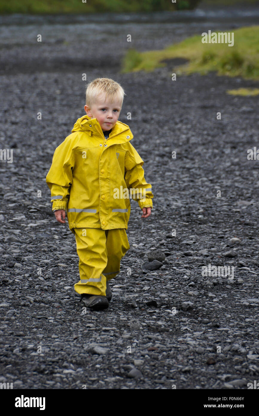 Young boy in yellow rain suit, Iceland Stock Photo