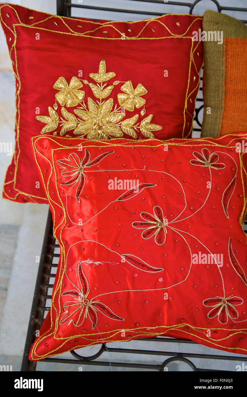 Bunch of decorative red satin shiny pillows, Example of product made by a Fair trade producer.India. Stock Photo