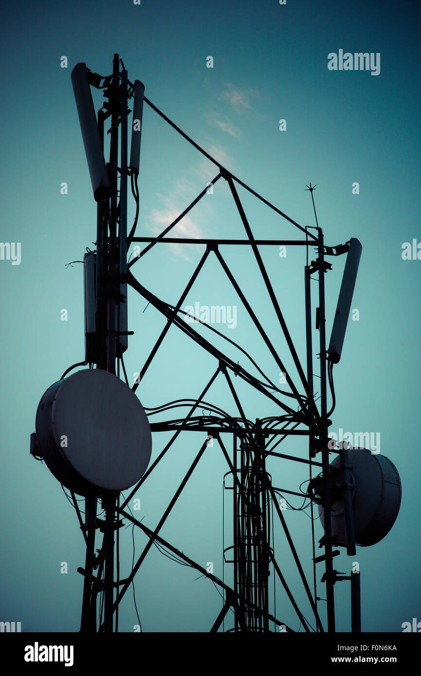 Silhouette of telecommunication radio tower . Blue toned image. Stock Photo