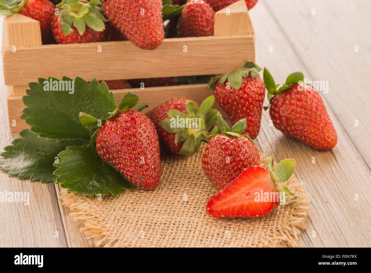 Strawberries over odl brown wooden table background Stock Photo - Alamy