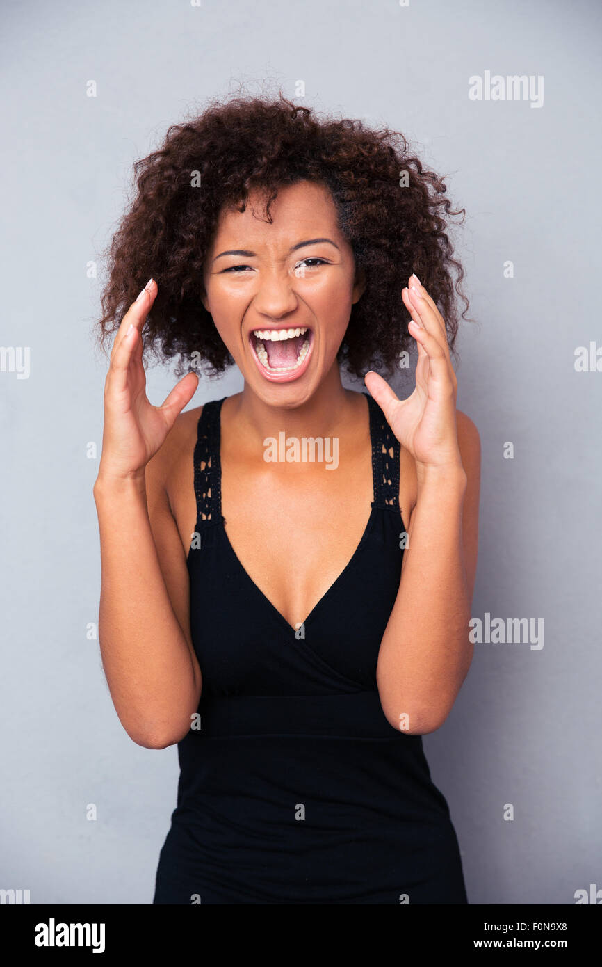 Portrait of african woman shouting over gray background Stock Photo