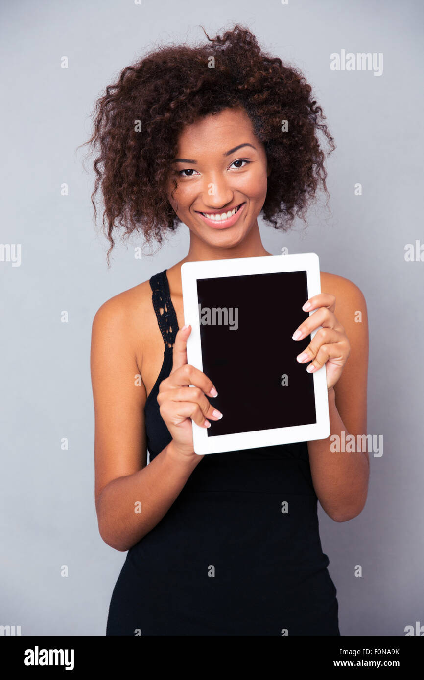 Portrait of a happy afro american woman showing blank tablet computer ...