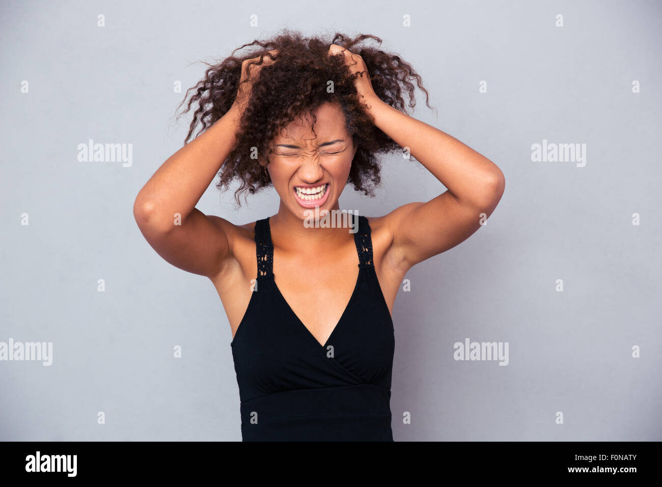 Portrait of afro american woman screaming over gray background Stock Photo