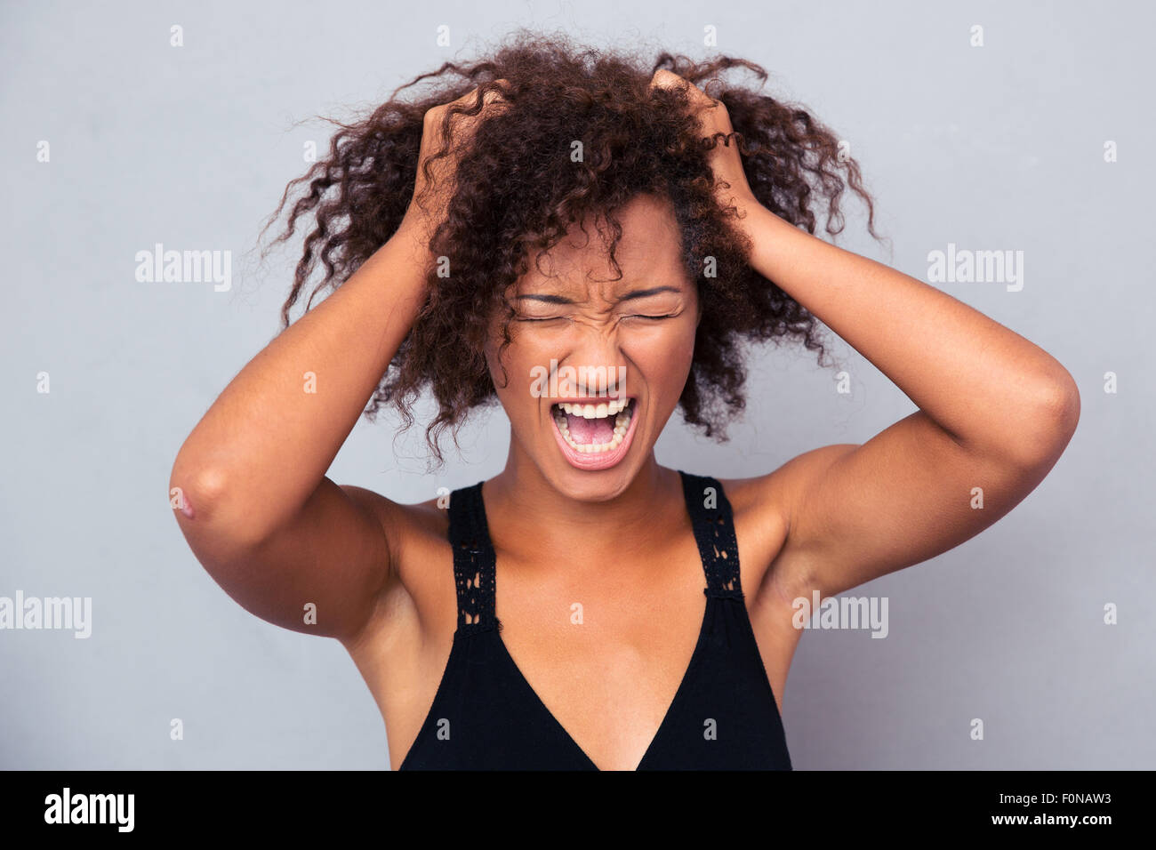 Portrait of afro american woman shouting over gray background Stock Photo