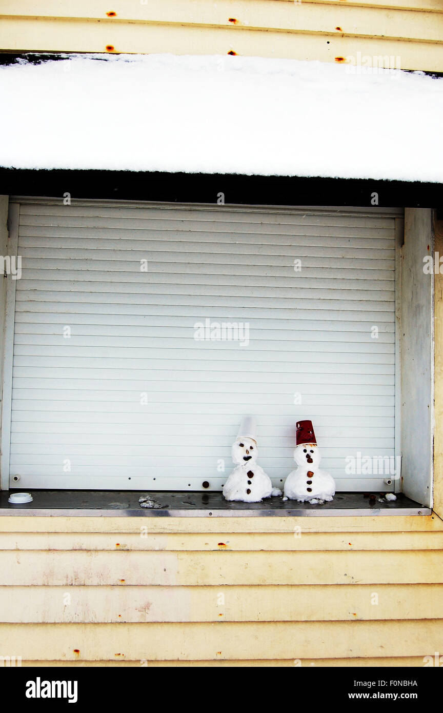two mini snowmen in a closed fast-food vending hatch in Brighton Stock Photo