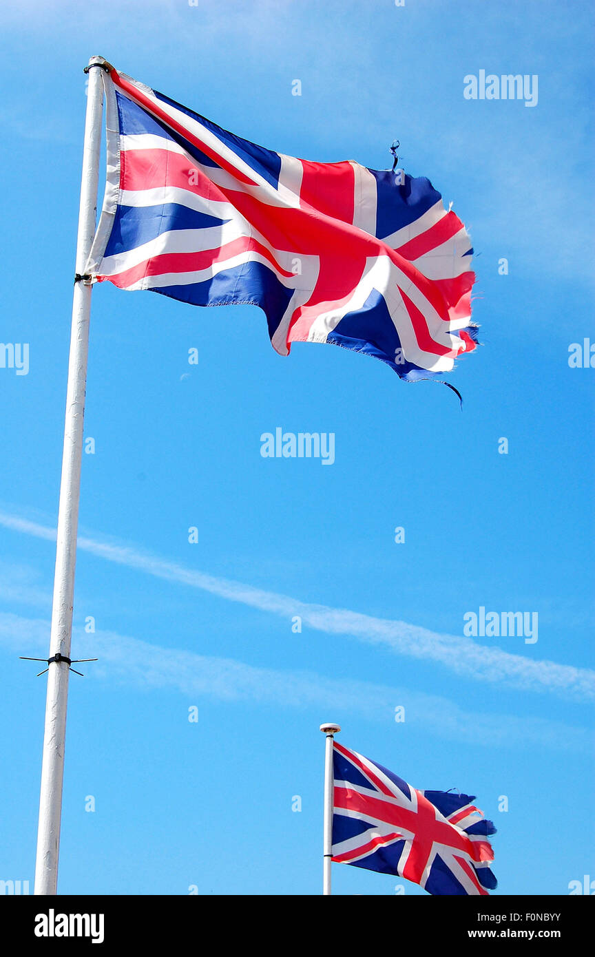Union jack flag flying in the wind against a blue sky Stock Photo