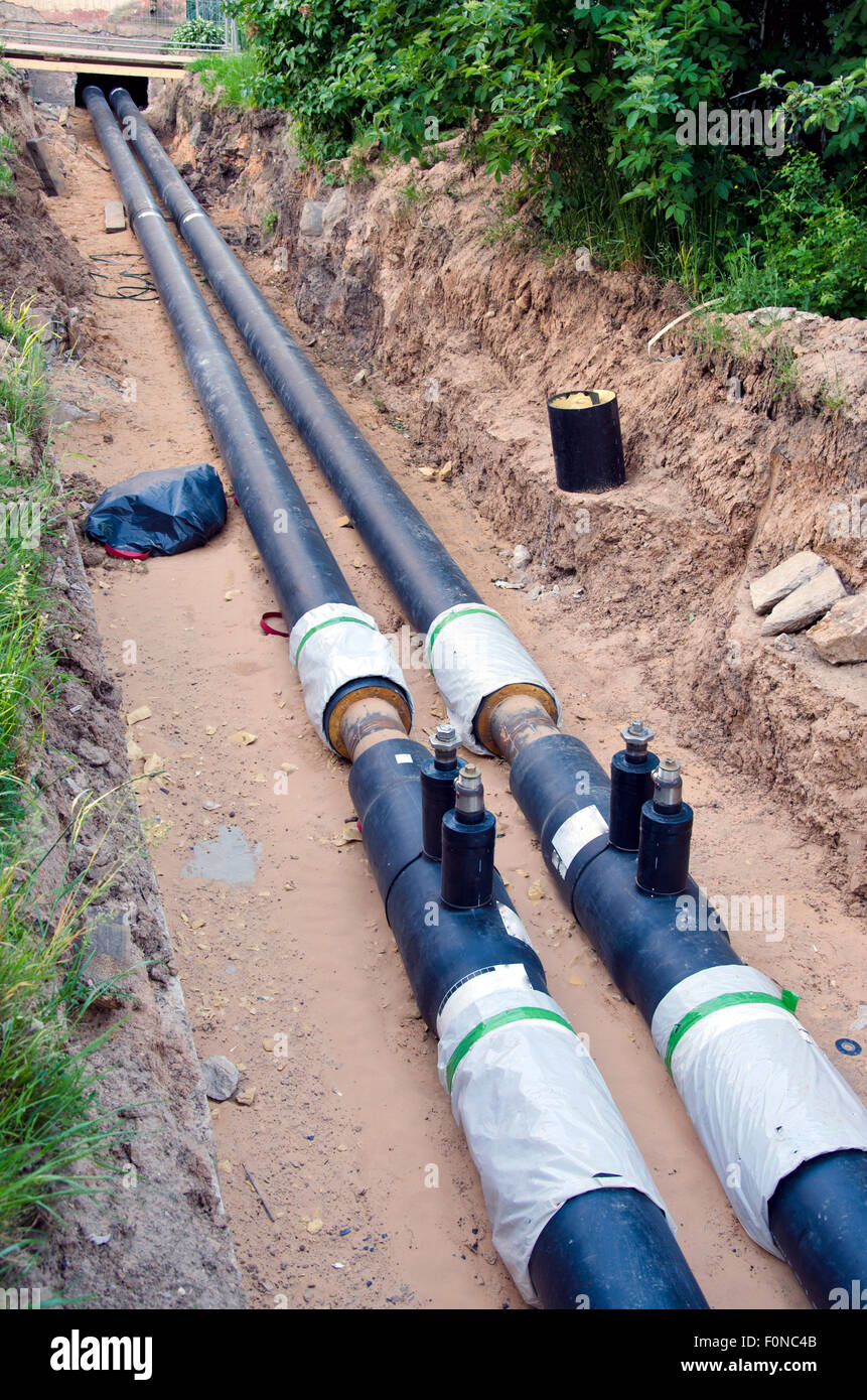 two black plastic central heating pipes coming out of house during