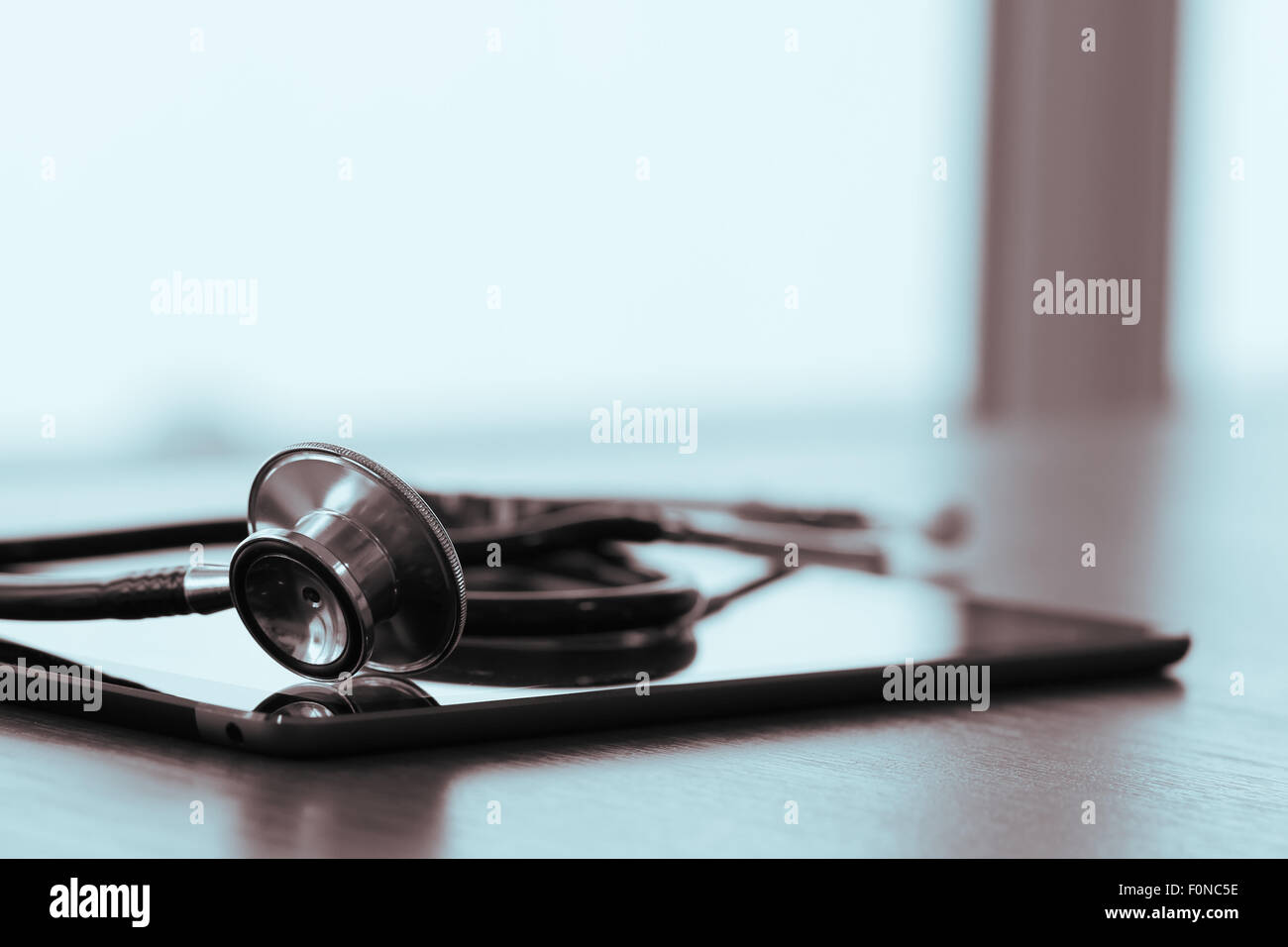 Studio macro of a stethoscope and digital tablet abstract on wood table ...