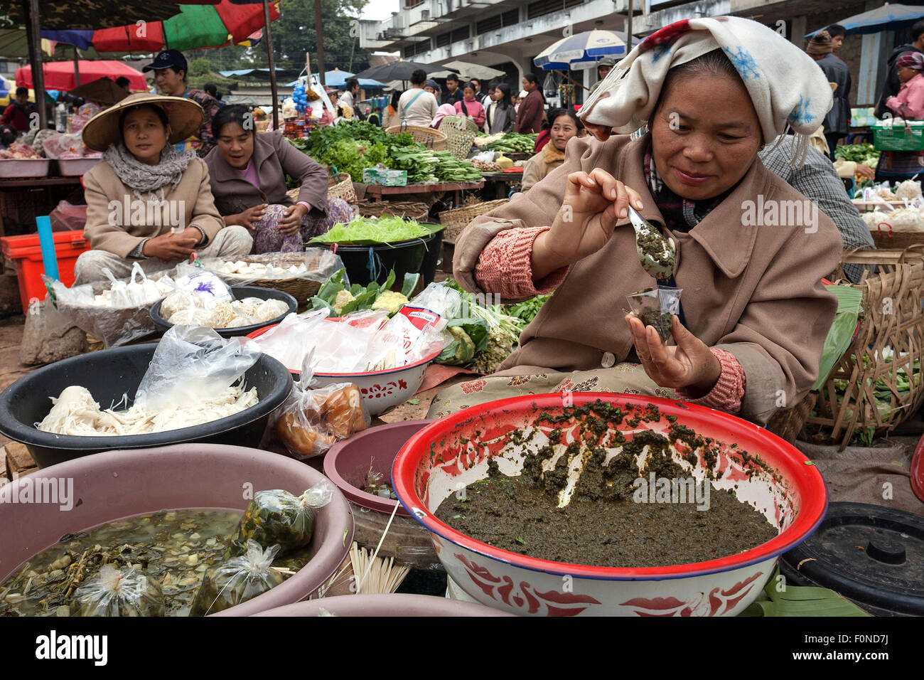Native woman filling paste into a cup, market, local market, Kyaing Tong, Shan State, Myanmar Stock Photo