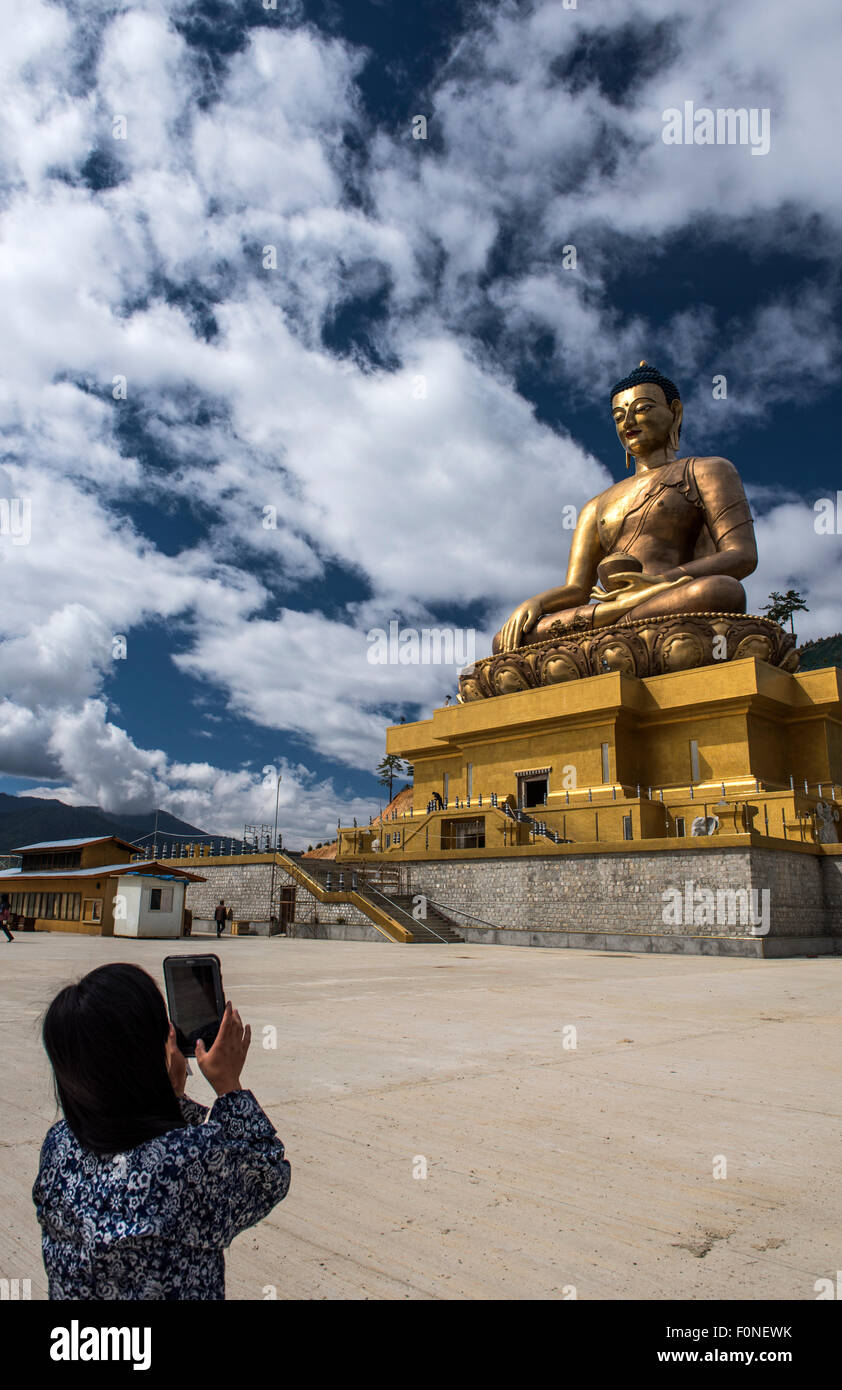 Woman taking pictures with mobile phone at Buddha Dordenma statue Thimpu Bhutan Stock Photo
