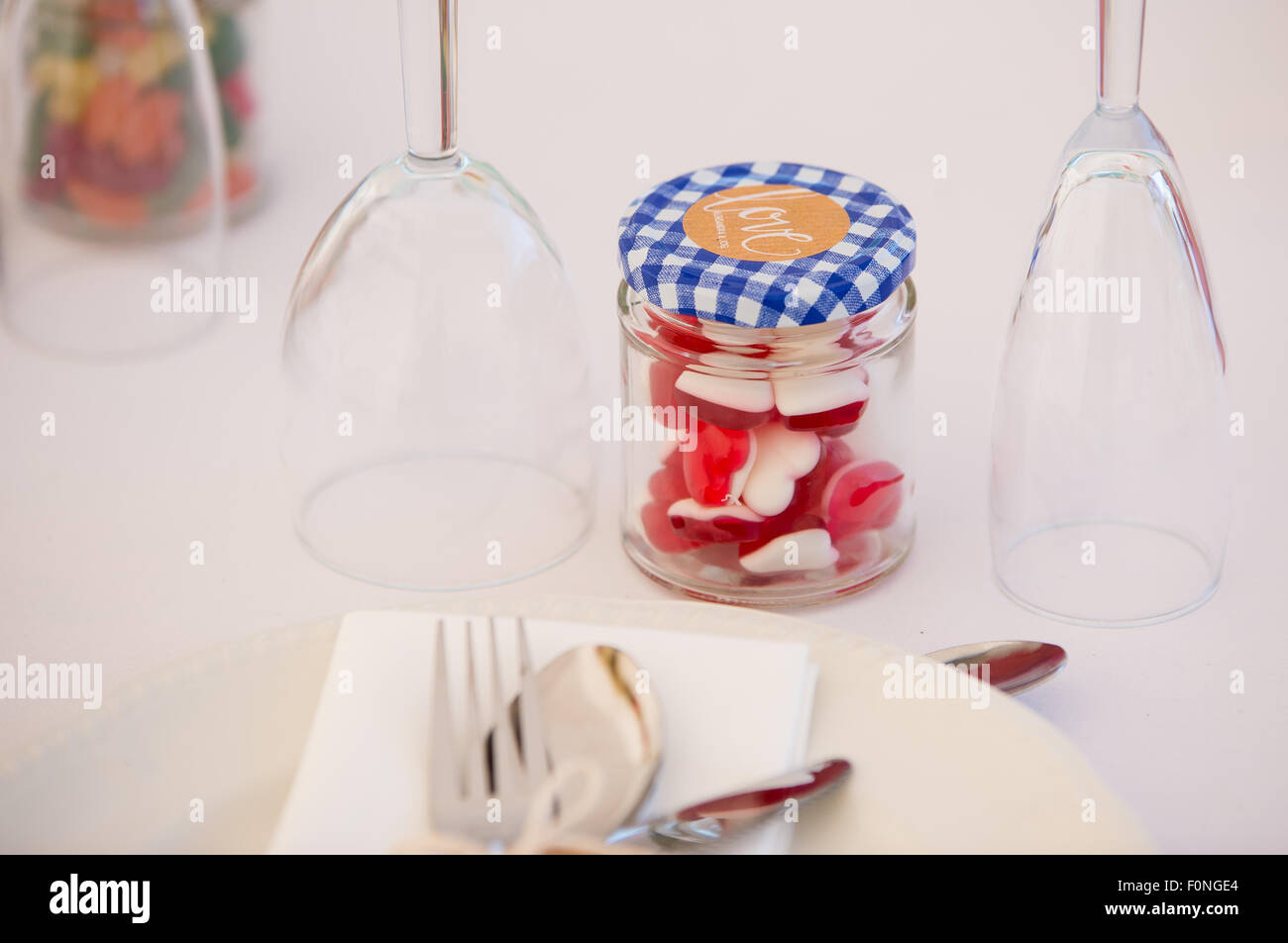 Love heart jelly sweets in a jar on a table as a wedding favor gift. Stock Photo