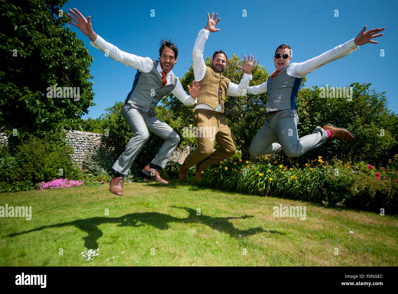 A groom and his 2 best men jump up in the air in excitement prior to the wedding ceremony. Stock Photo