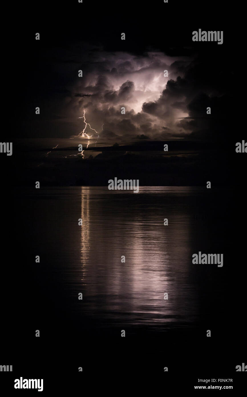 Lighting on the horizon reflected in the ocean in Indonesia, Asia Stock