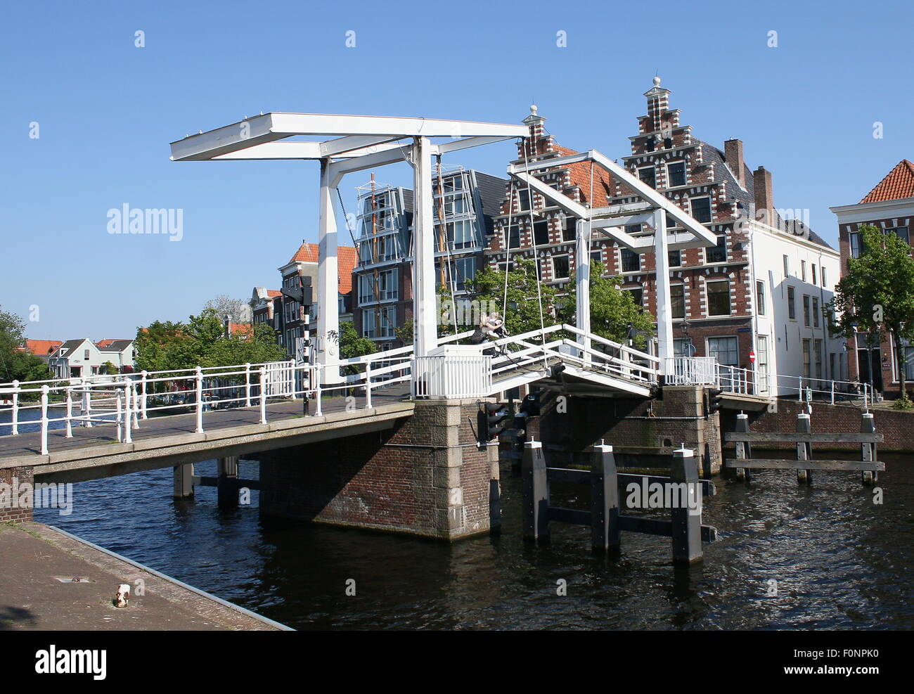 17th century Gravestenenbrug, an old wooden bridge over Spaane River, city centre of Haarlem, The Netherlands. Behind the bridge warehouse De Olyphant Stock Photo