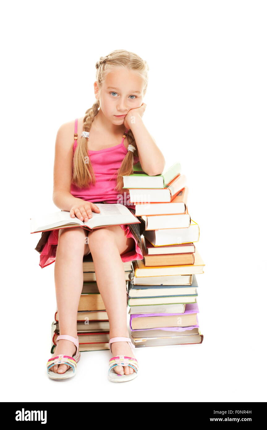 Little schoolgirl sitting on a stack of books Stock Photo - Alamy