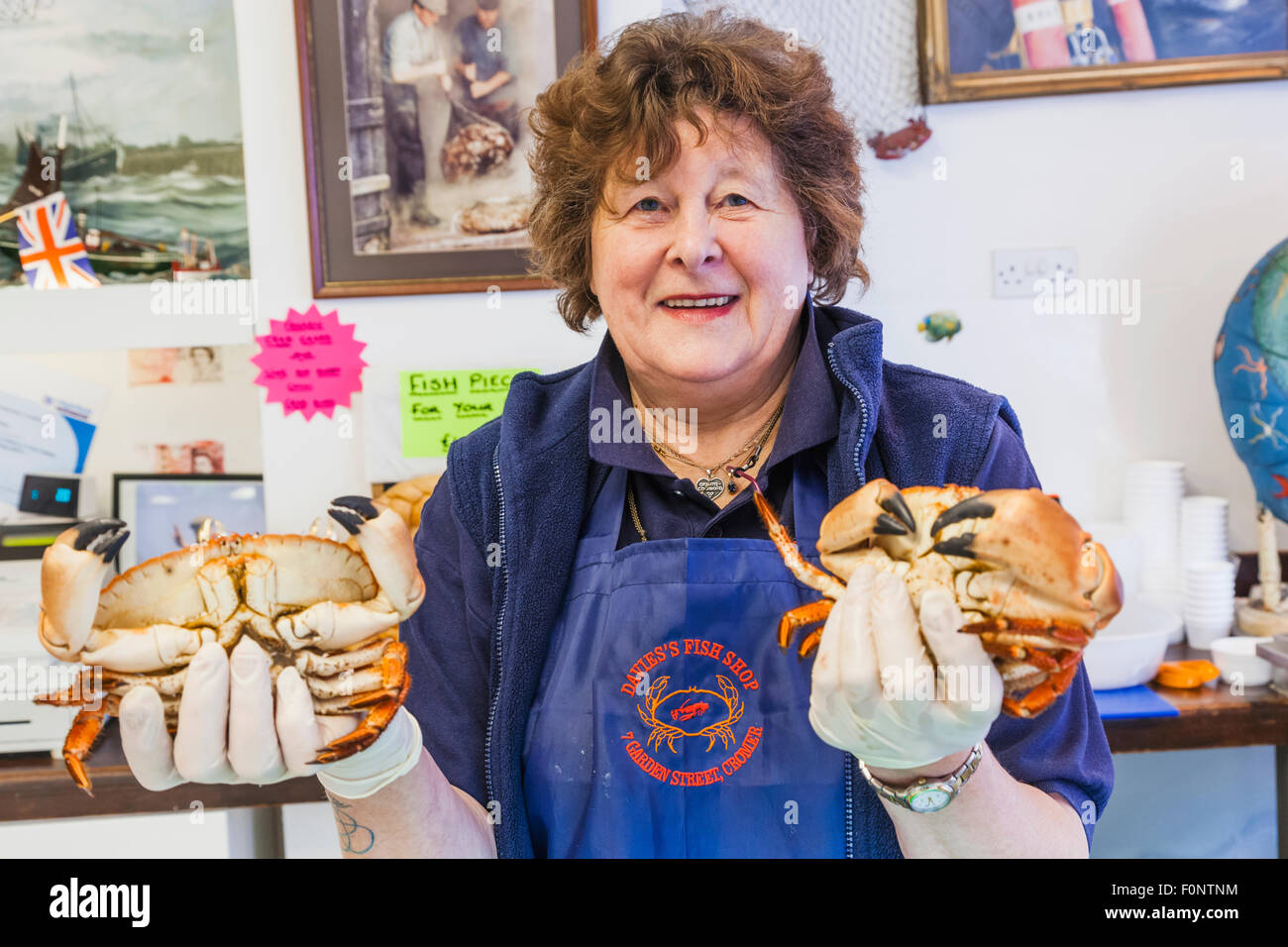 England, Norfolk, Cromer, Fishmonger Holding Cromer Crabs Stock Photo