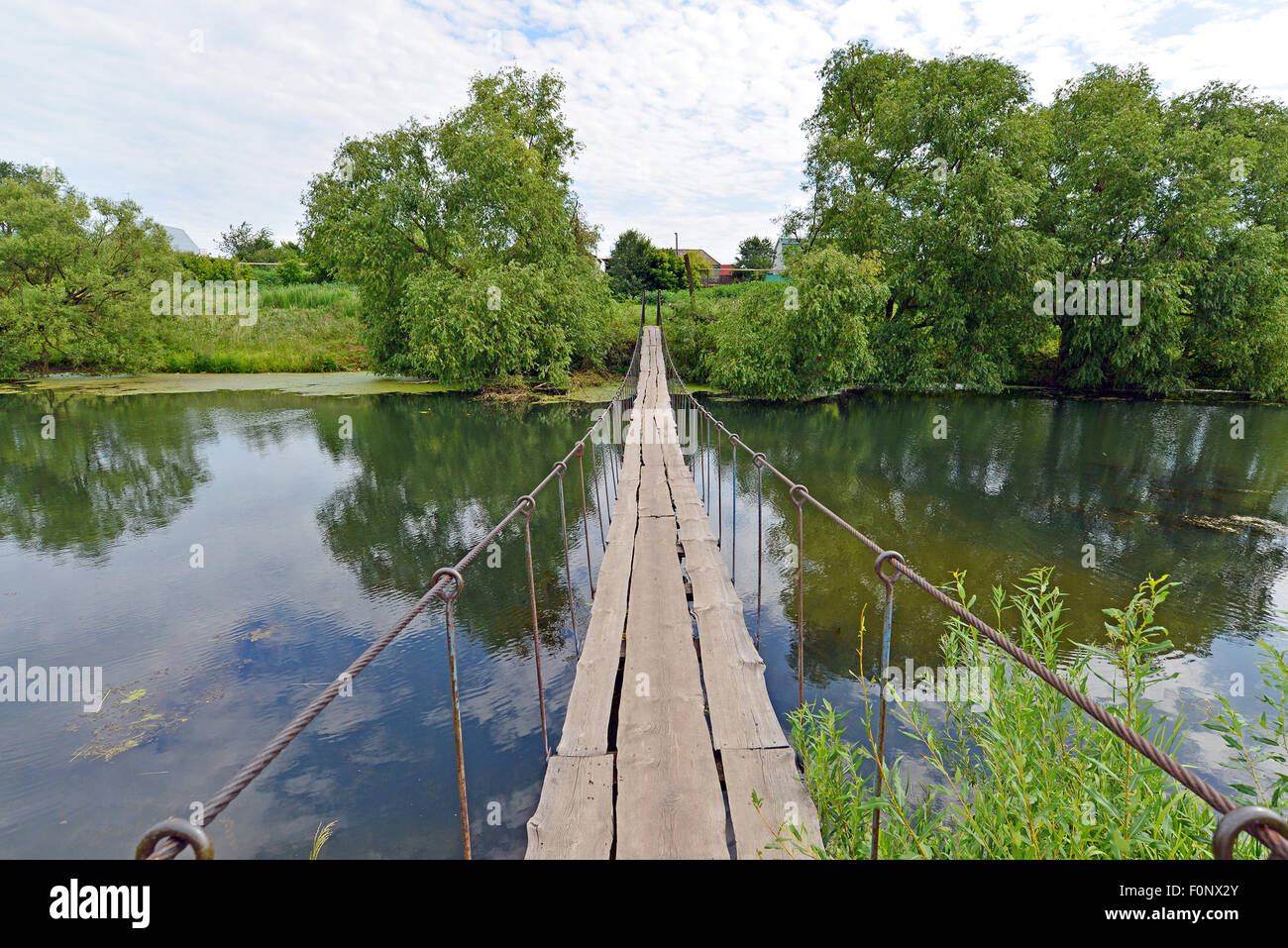 Hanging pedestrian bridge across the river in the summer Stock Photo ...