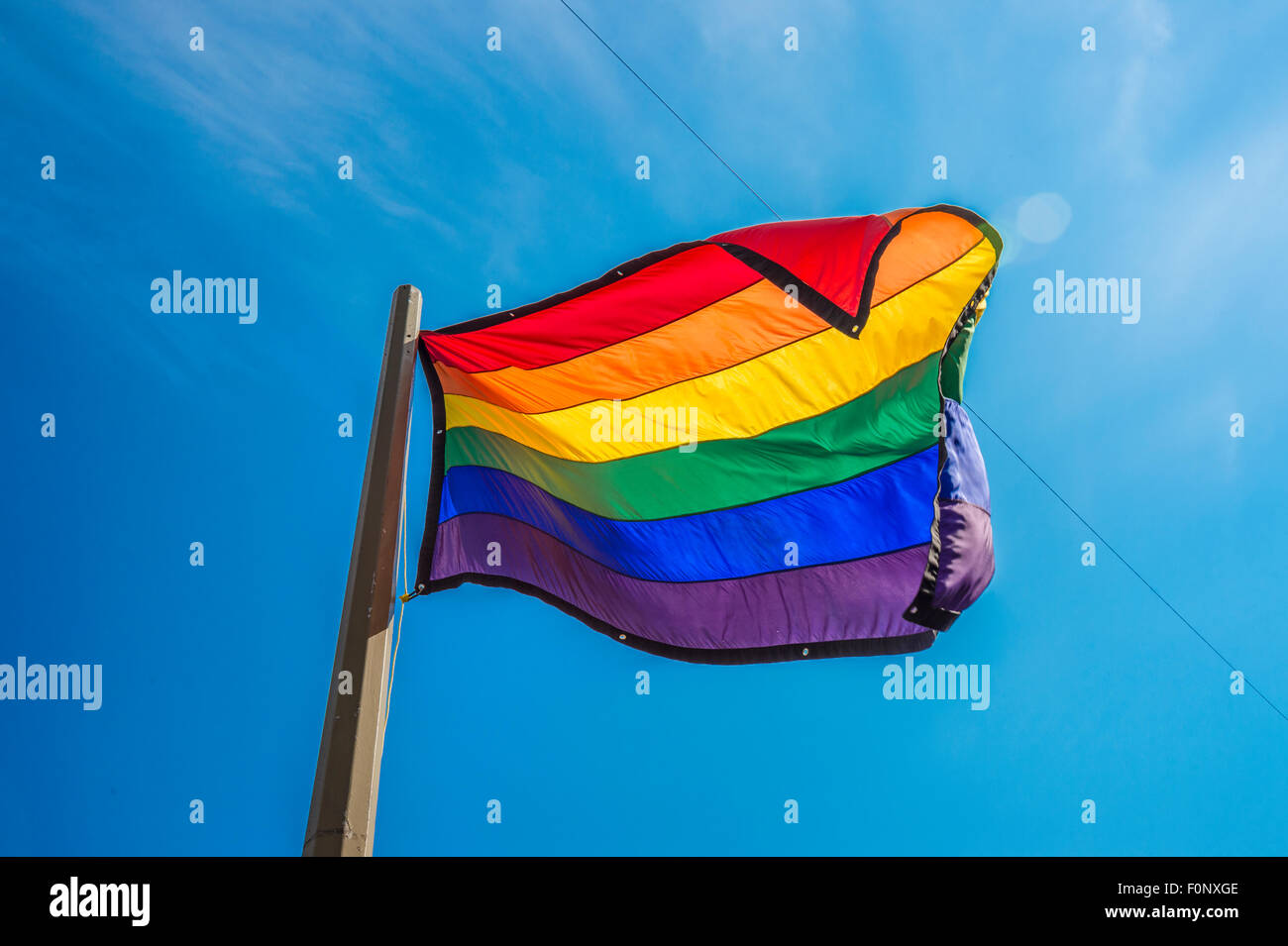 Gay rainbow flag over blue sky Stock Photo