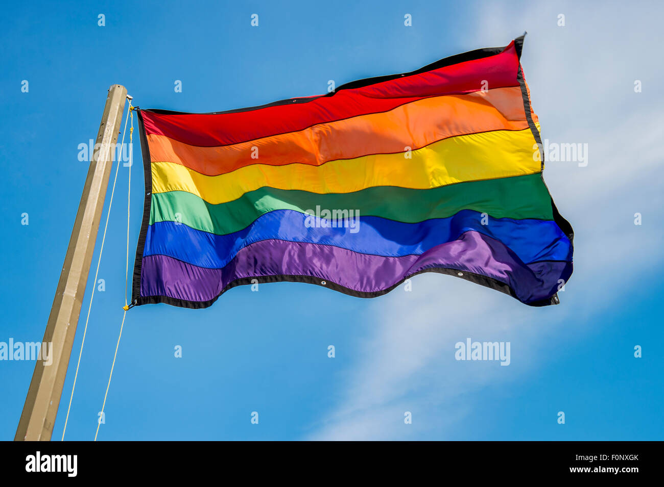 Gay rainbow flag over blue sky Stock Photo