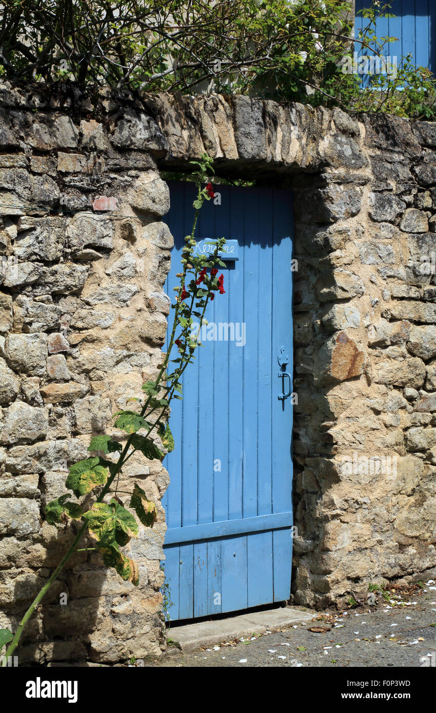 Blue door in stone wall in Rue du Vrai Secours, Ile d'Arz, Morbihan, Brittany, France Stock Photo