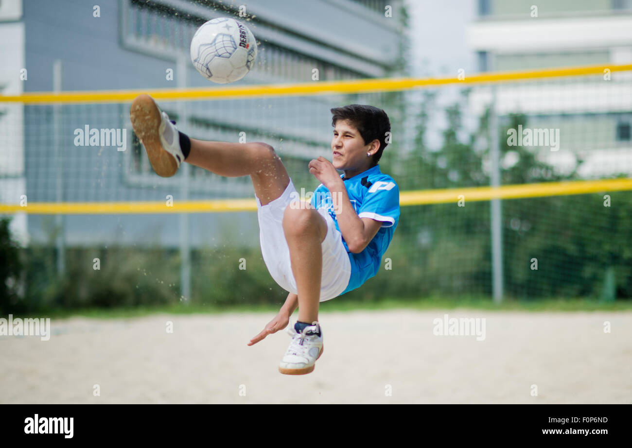 Hildesheim, Germany. 19th Aug, 2015. The young refugee Nohad (12) from Syria plays soccer during the integration project 'FuNah' at the university of Hildesheim, Germany, 19 August 2015. The refugee project 'FuNah' (Fußball & Nachhilfe = lit. soccer & tutoring) connects individual tutoring and playing soccer with German students. Photo: JULIAN STRATENSCHULTE/dpa/Alamy Live News Stock Photo