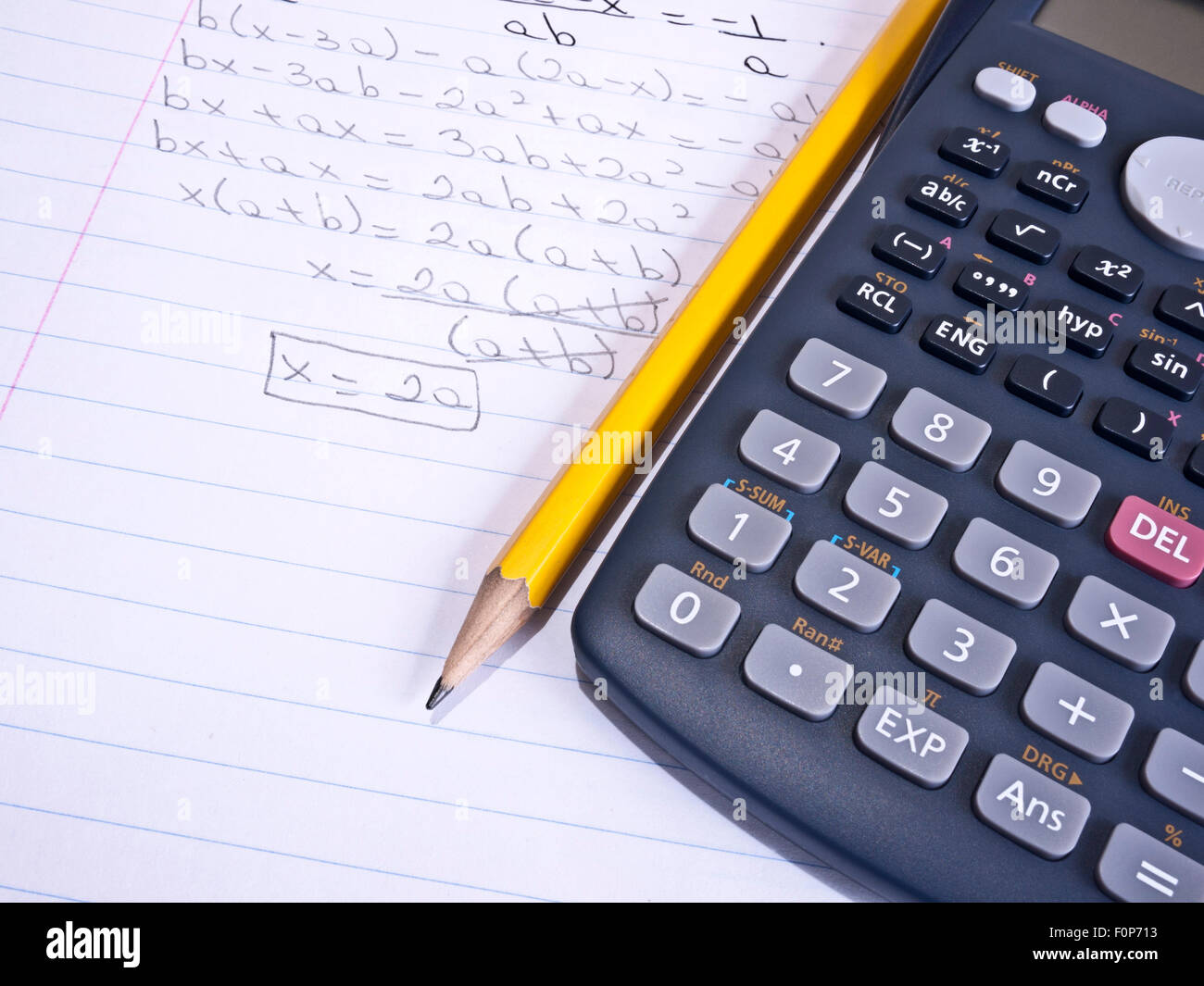 Macro shot of a calculator over a page with a math problem and a yellow pencil Stock Photo