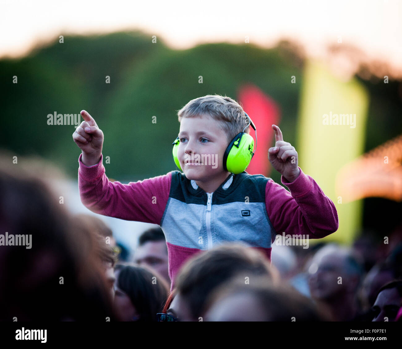 Boy watching a band on parents shoulders at music festival uk Stock Photo
