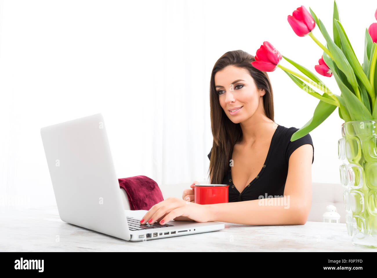 A young beautiful woman using a Laptop computer at home Stock Photo - Alamy