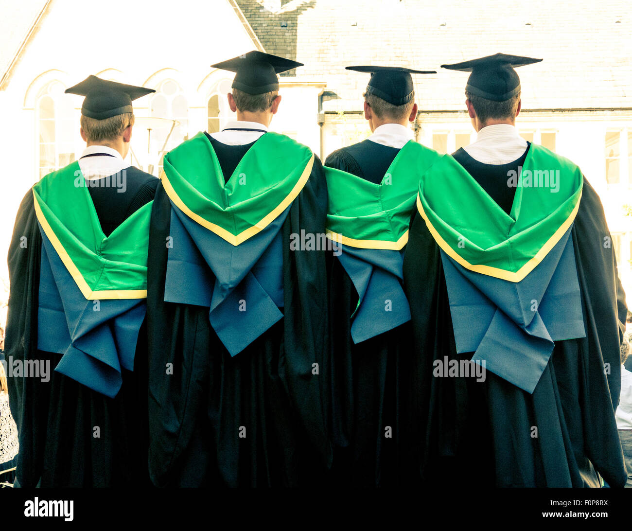 New graduates wearing traditional cap and gown seen from behind on graduation day Stock Photo