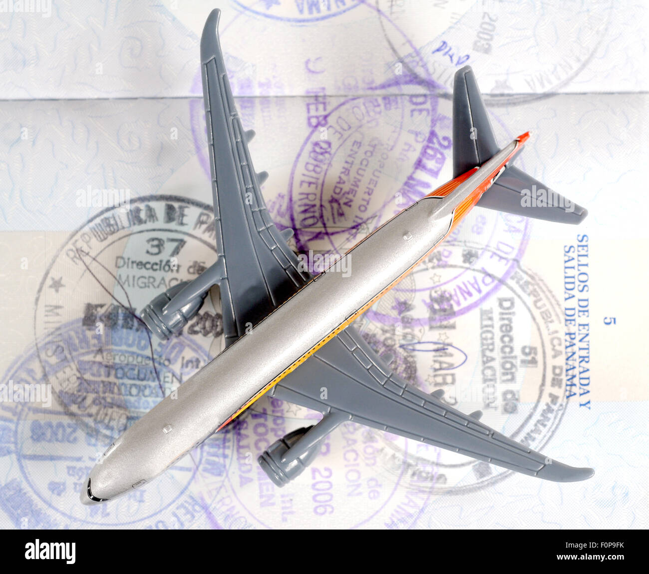 Toy plane over an open passport showing travel seals Stock Photo