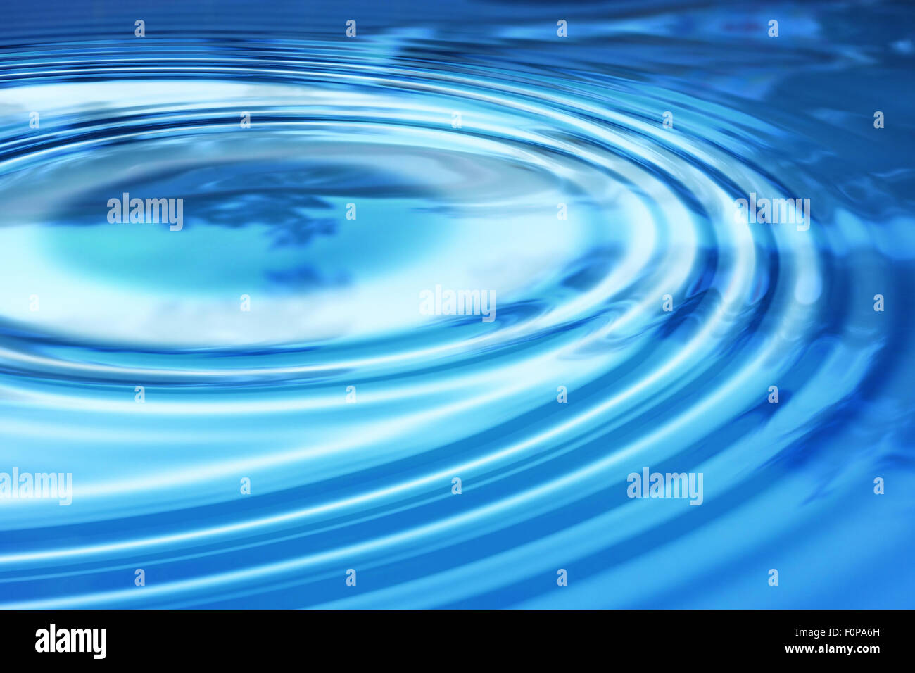 water ripple waves across a clear blue pond Stock Photo