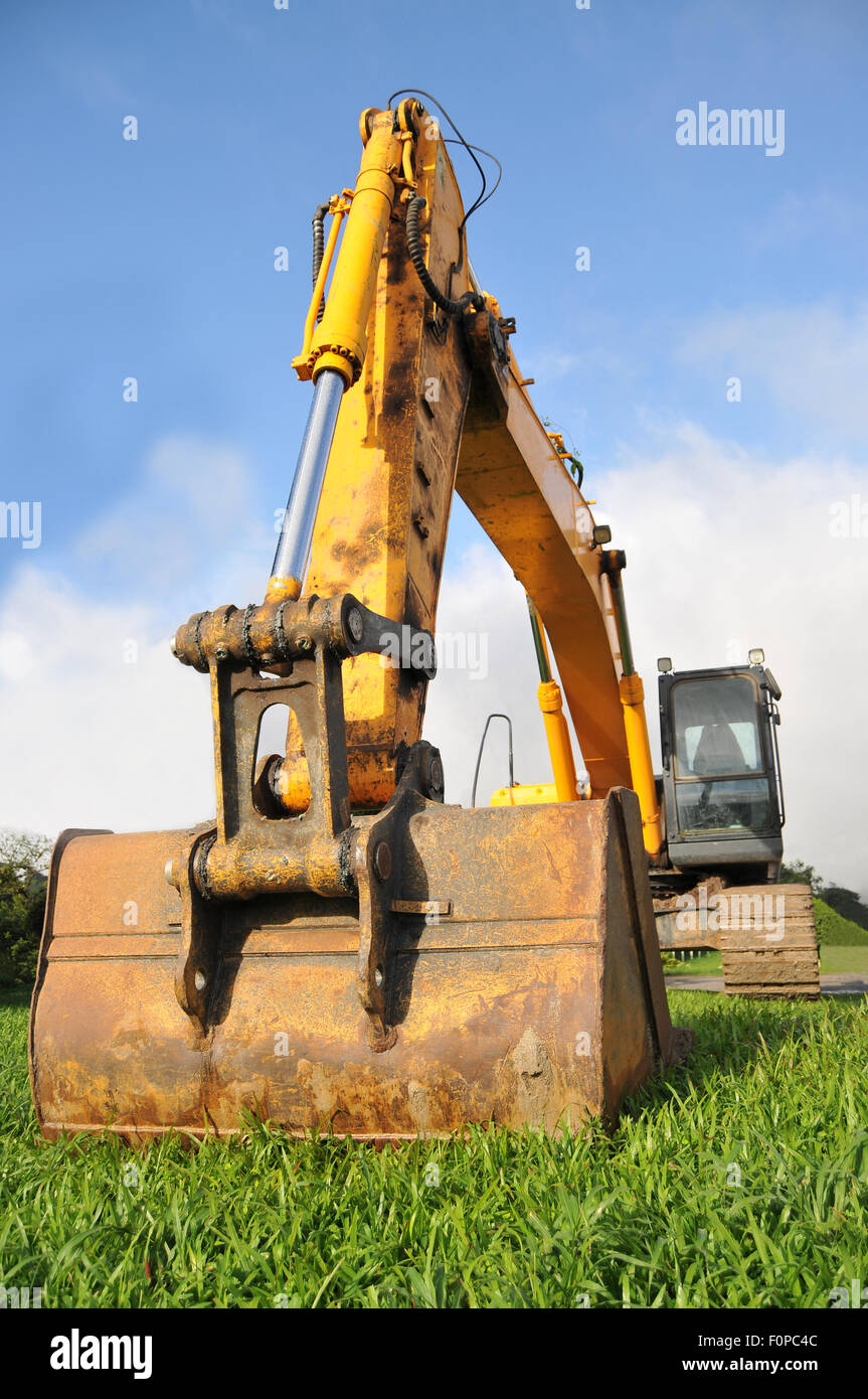 Huge excavator on a green field ready to work Stock Photo