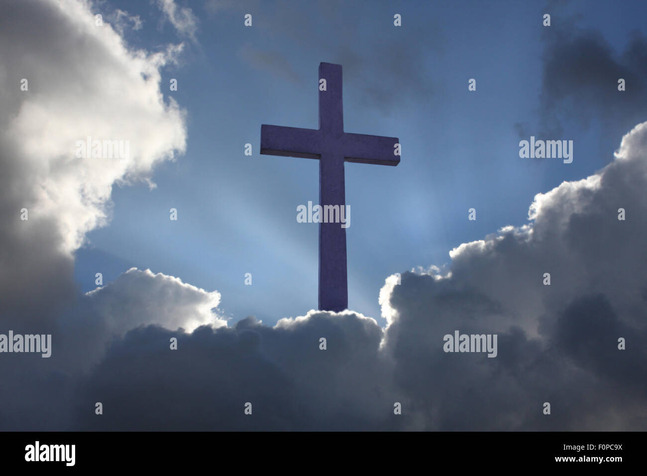 Christian cross coming out of clouds Stock Photo