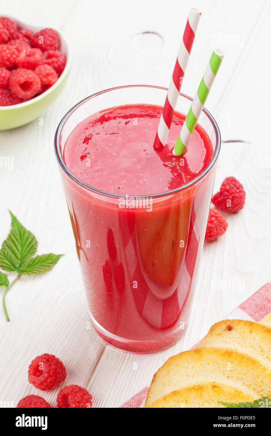 Raspberry smoothie, cake and berries on wooden table Stock Photo