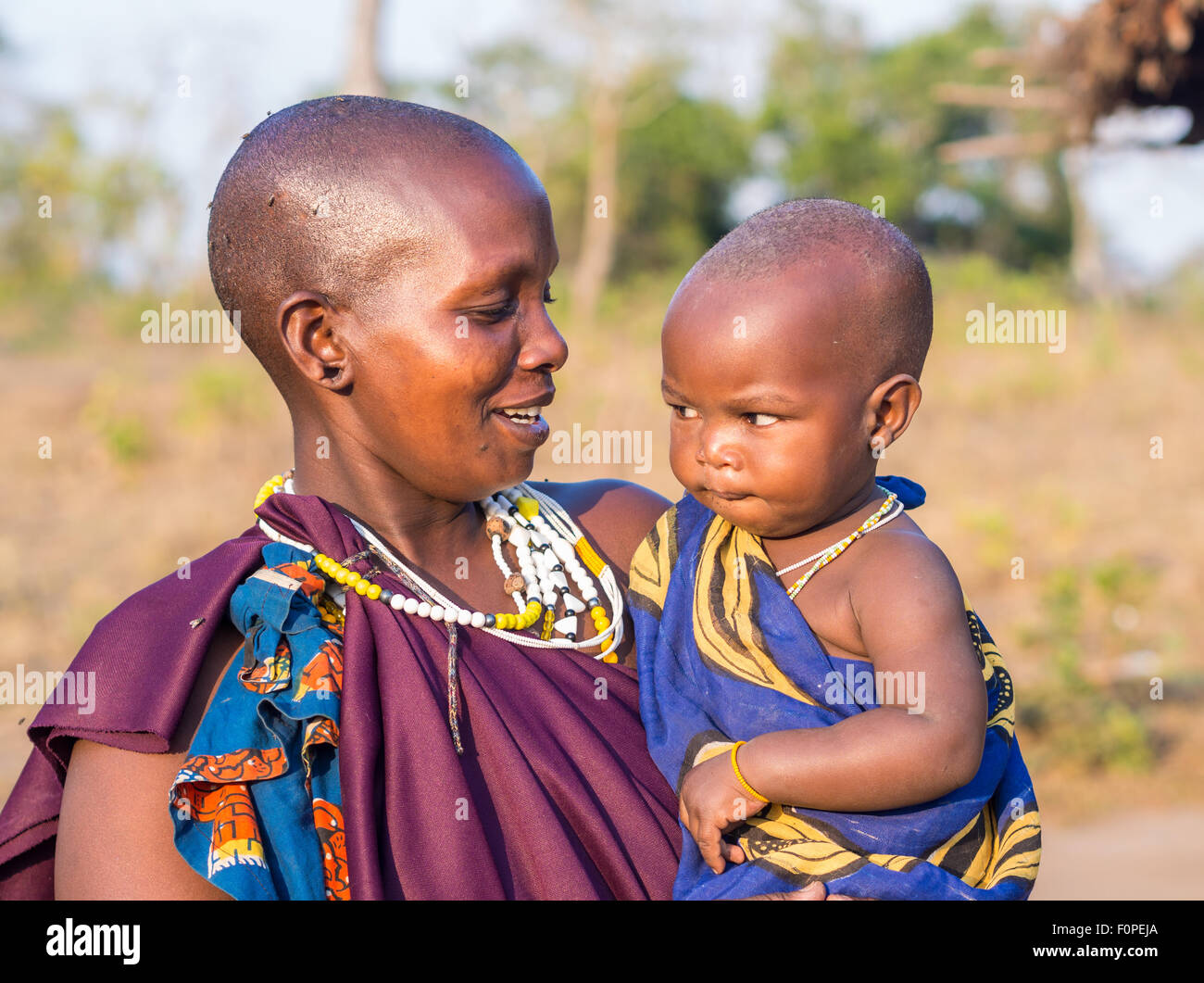 Maasai mother holding her child in her arms in their boma (village) in Tanzania, Africa. Stock Photo
